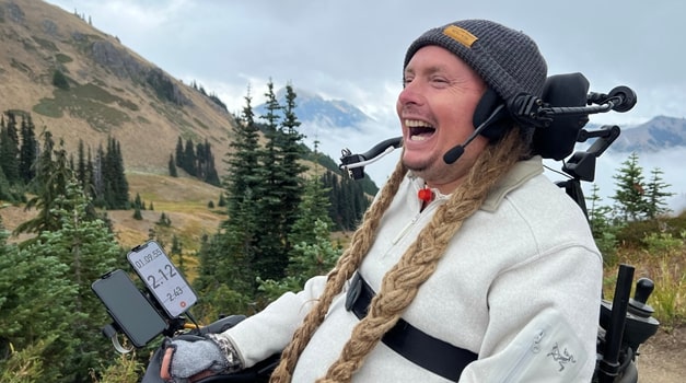 Ian beaming with happiness while scaling the path of a mountain range