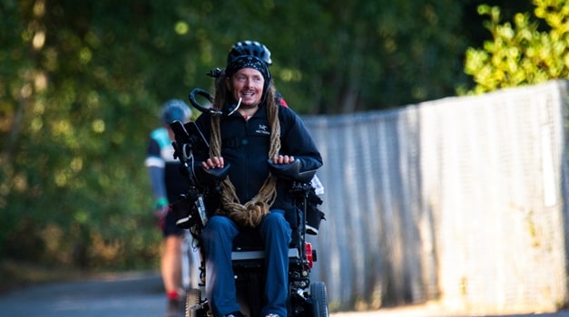 Ian riding in his Invacare TDX SP2 power wheelchair alongside his team